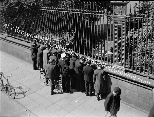 SPECTATOR WATCH CRICKET THROUGH RAILINGS OF COLLEGE PARK T.C.D.